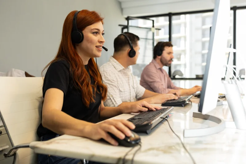 Woman on computer and with headset assisting